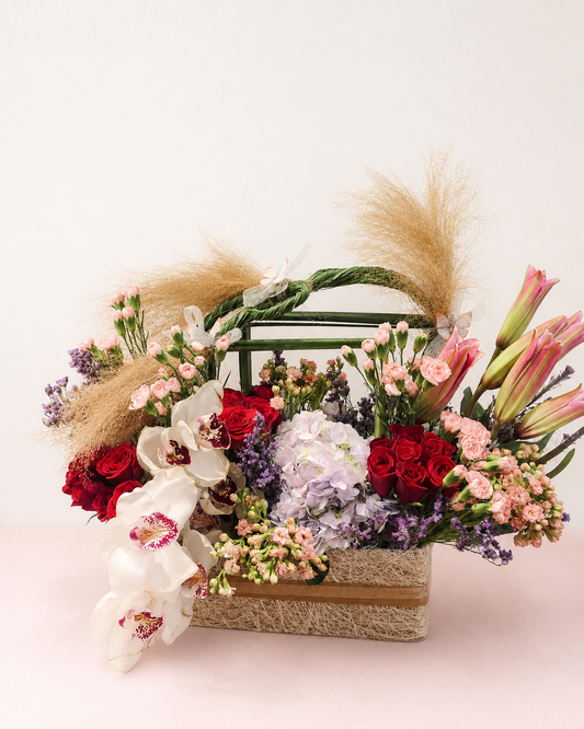 White cymbidium orchids and red roses in a luxury flower basket by James Flowers Mumbai